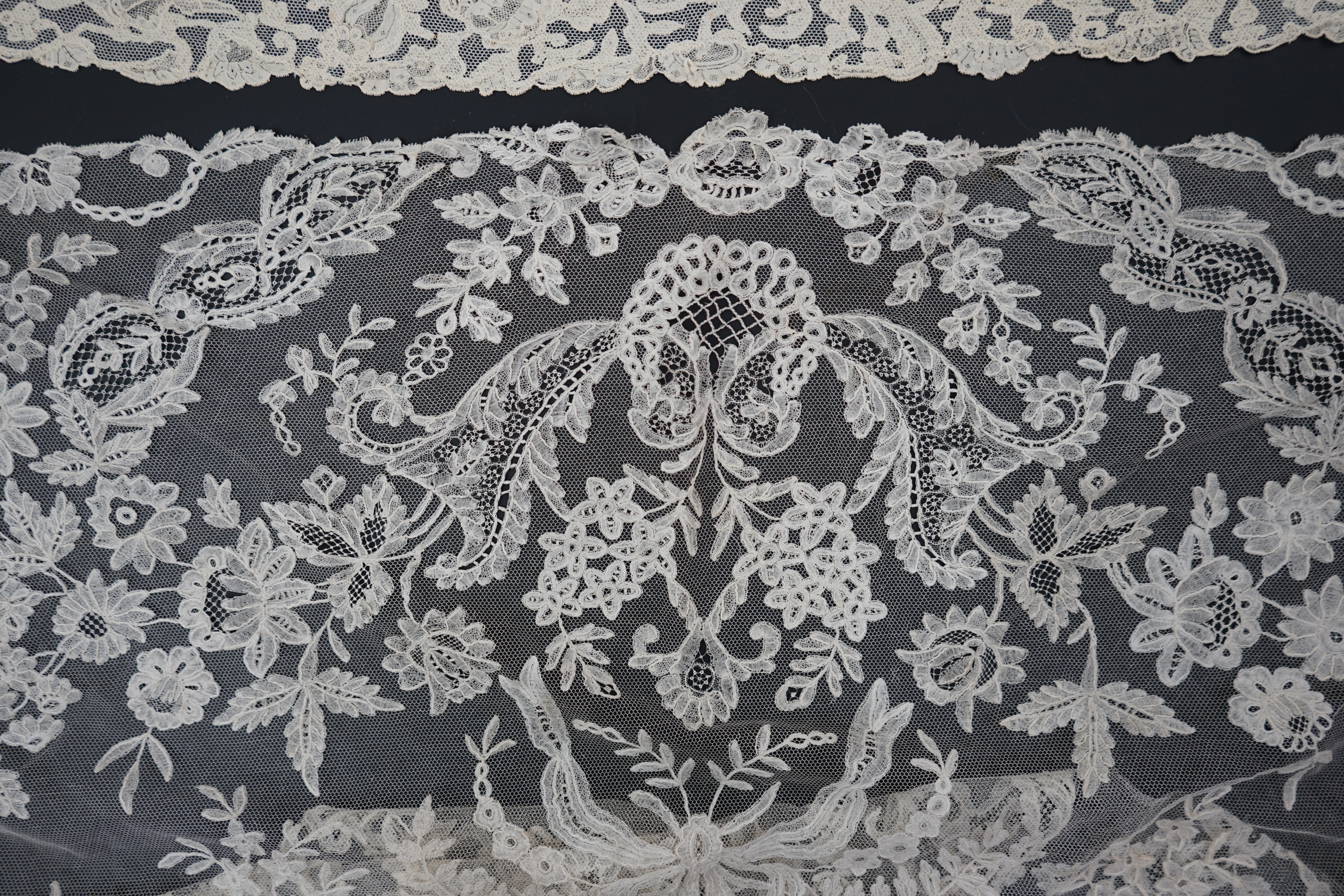 A large section of an ornate 19th century Brussels bobbin lace wedding veil, with two finished edges and one cut edge together with 18th century and later needle lace, an Argentan and an Alencon trimming, possibly an 18t